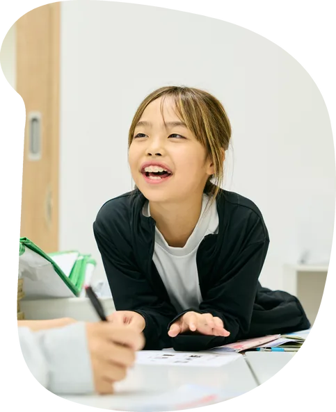 机に向かって楽しそうに学ぶ女の子